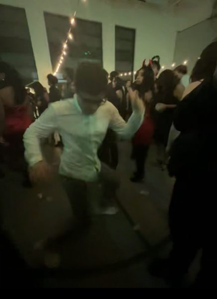 Nick Avdalian enthusiastically dances while a crowd of peers cheer him on.